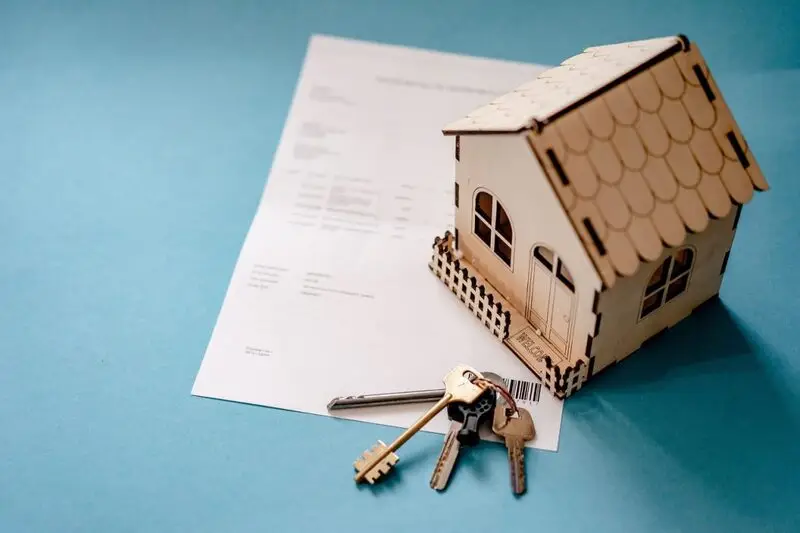 miniature house with documents and keys