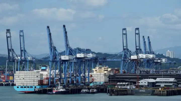 Cargo shipping port with large blue cranes and container ships docked at a Panama Canal terminal