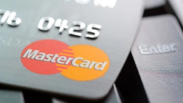 Close-up of Mastercard logo on credit card surface crypto