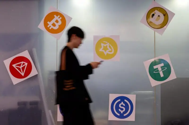 A man walks past a cryptocurrency exchange store after Bitcoin soars above $100,000