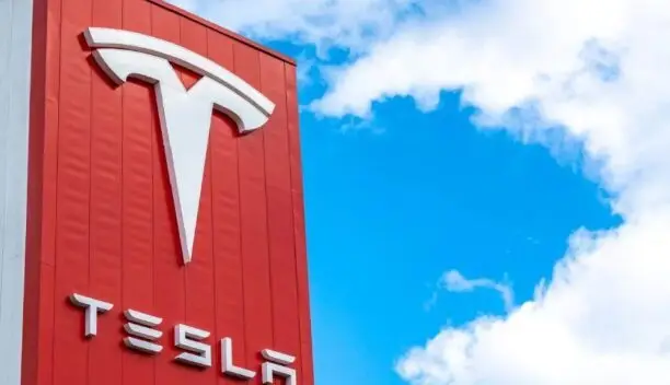Tesla logo on red building against blue sky
