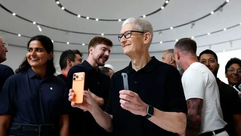 Cook holding iPhone 17 at event